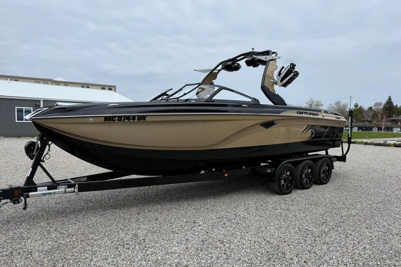 Slide: The Image of 2019 Centurion Ri257 boat on trailer, parked on gravel, with overcast sky. - 10