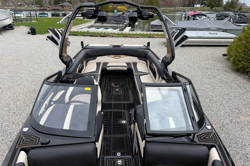 Slide: The Image of 2019 Centurion Ri257 boat interior with sleek black and beige design, docked near water. - 16