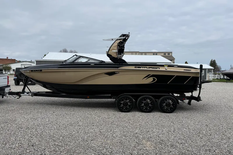 Slide: The Image of 2019 Centurion Ri257 boat on trailer, parked on gravel, with overcast sky. - 9