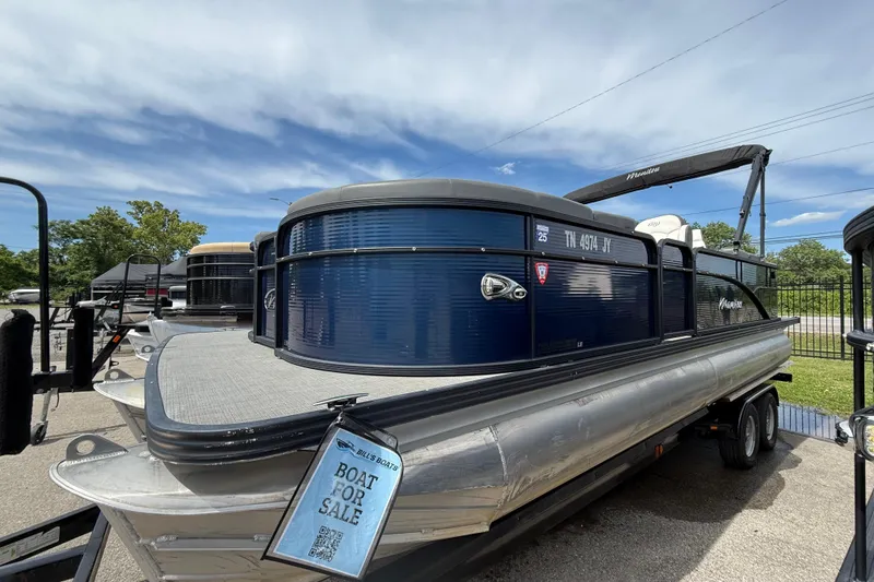 The Image of 2022 Manitou Aurora LE pontoon boat for sale, displayed on a trailer under a clear sky. - 0