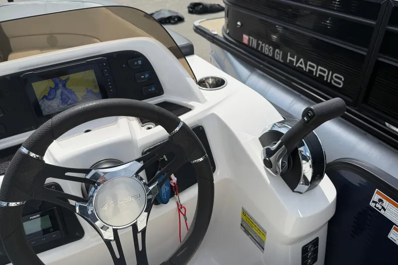 Slide: The Image of 2022 Manitou Aurora LE boat dashboard with steering wheel and control panel. - 10
