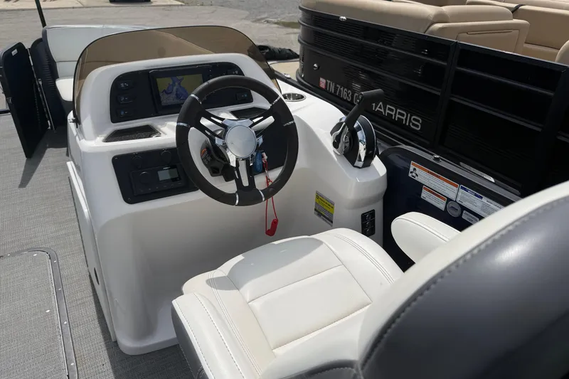 Slide: The Image of 2022 Manitou Aurora LE boat cockpit with steering wheel and navigation display. - 9