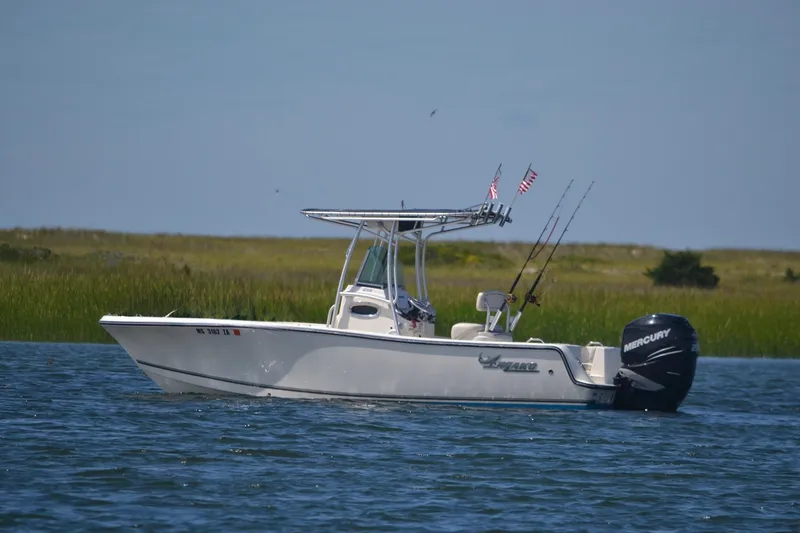 The Image of 2015 Mako 214 Center Console boat on water with fishing rods and Mercury engine. - 0