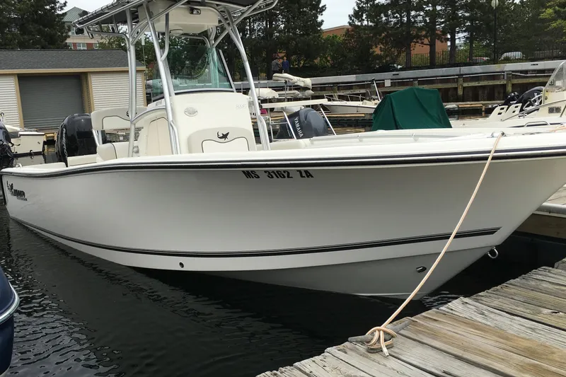 Slide: The Image of 2015 Mako 214 Center Console boat docked at a marina. - 1