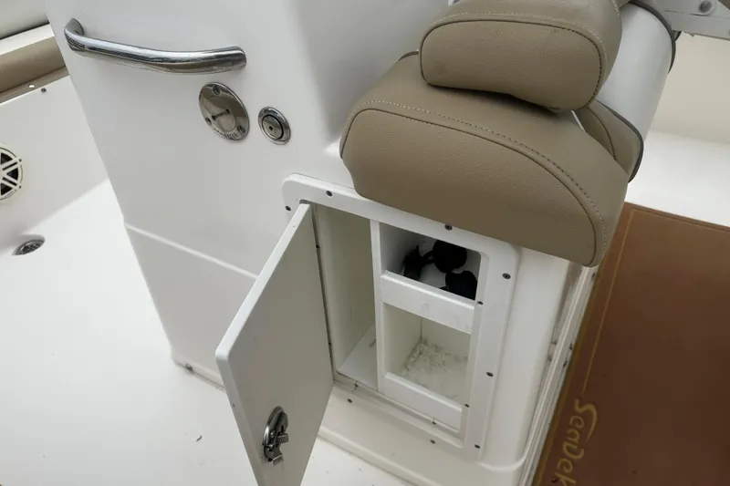Slide: The Image of 2019 Key West 239 FS boat storage compartment with open door and cushioned seat. - 5