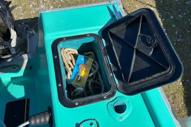 Slide: The Image of Open storage compartment on a 1971 Chrysler 15 CC boat with rope and packaging inside. - 16