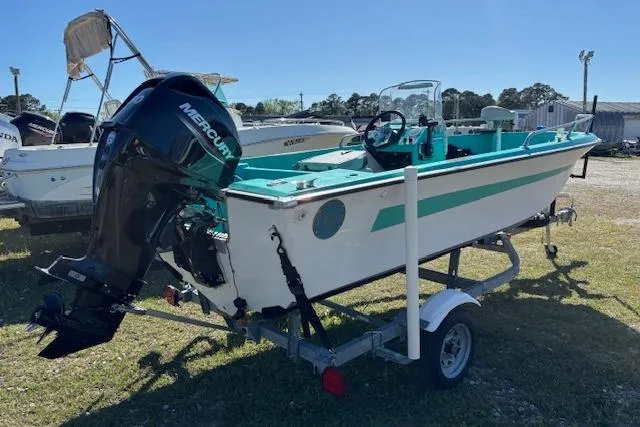 Slide: The Image of 1971 Chrysler 15 CC boat with Mercury outboard motor on a trailer, parked outdoors. - 3