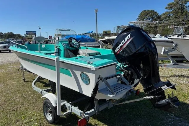 Slide: The Image of 1971 Chrysler 15 CC boat with Mercury outboard motor on a trailer, parked outdoors. - 6