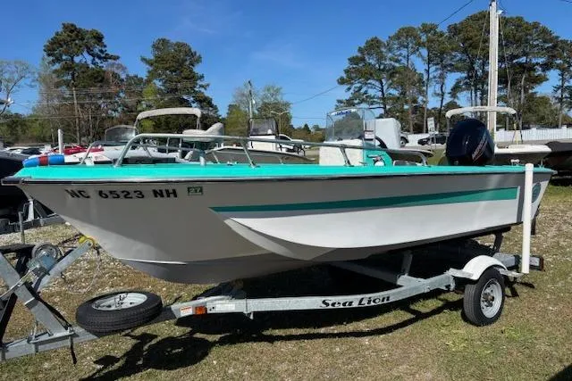 Slide: The Image of 1971 Chrysler 15 CC boat on trailer, white with teal accents, parked outdoors. - 7