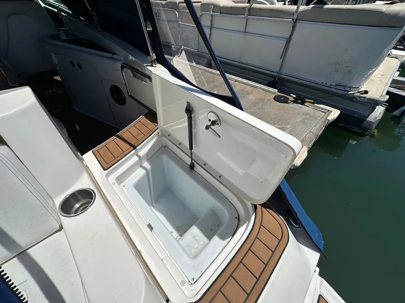 Slide: The Image of 2014 Sea Ray 260 Sundeck with open storage compartment at dock. - 24