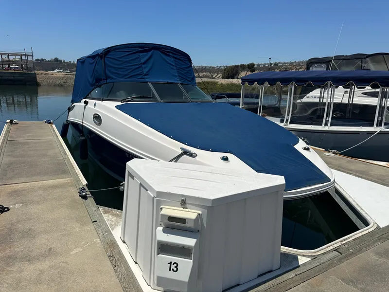 Slide: The Image of 2014 Sea Ray 260 Sundeck docked with blue cover. - 33