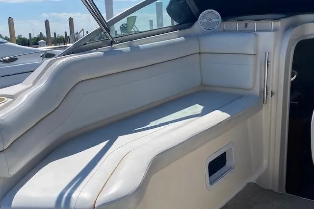 Slide: The Image of 2005 Rinker Fiesta Vee 250 boat interior with white seating and window view. - 10