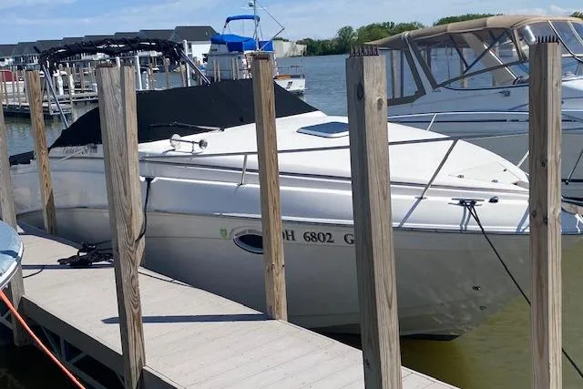 Slide: The Image of 2005 Rinker Fiesta Vee 250 docked at a marina, covered and ready for use. - 2