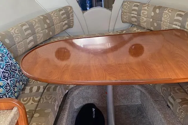 Slide: The Image of 2005 Rinker Fiesta Vee 250 cabin interior with wooden table and patterned seating. - 4