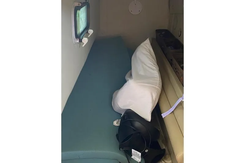 Slide: The Image of 2005 Rinker Fiesta Vee 250 cabin interior with bed and porthole window. - 5