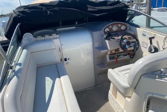Slide: The Image of 2005 Rinker Fiesta Vee 250 boat interior with steering wheel and seating area. - 9