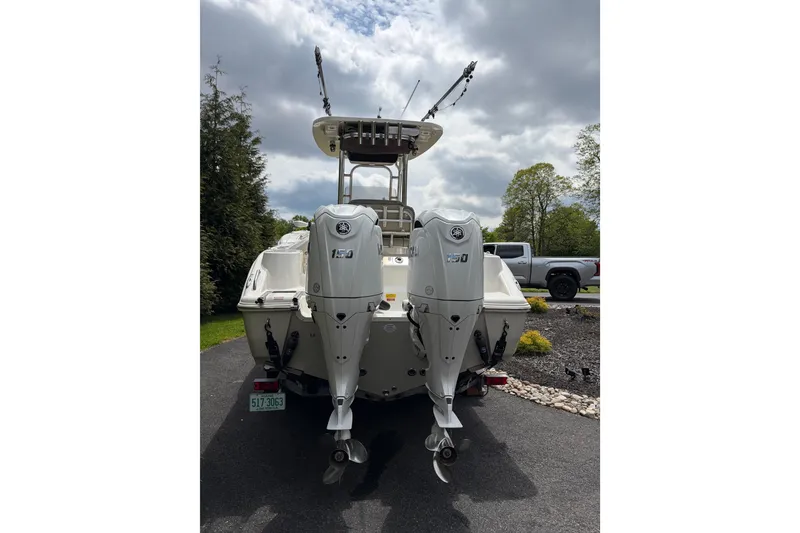 Slide: The Image of 2024 Key West 244 Center Console boat with dual outboard motors on a driveway. - 3