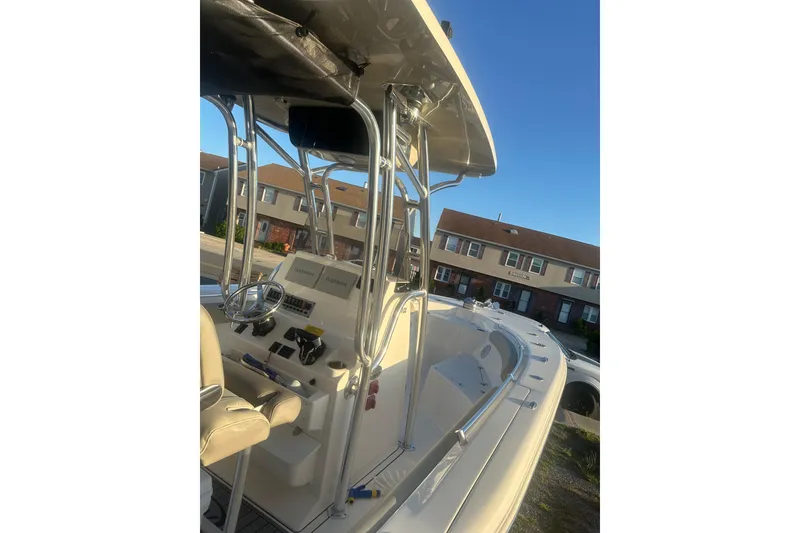 Slide: The Image of 2024 Key West 244 Center Console boat with steering wheel and controls, parked outdoors. - 8