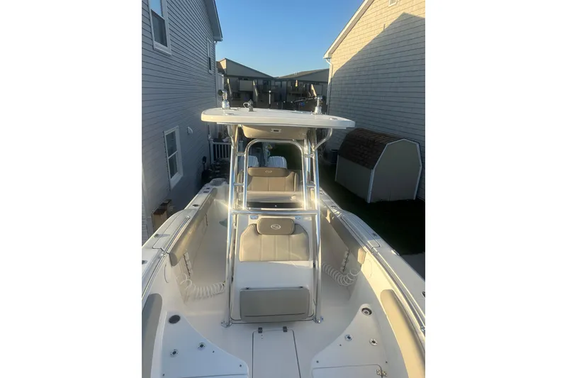Slide: The Image of 2024 Key West 244 Center Console boat docked between houses. - 9