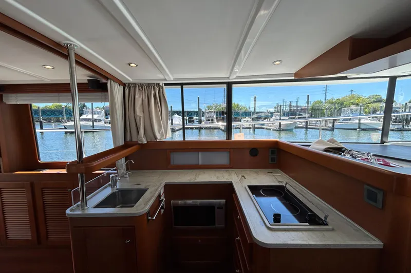 Slide: The Image of Interior of 2018 Beneteau Swift Trawler 44 with modern kitchen and marina view. - 10
