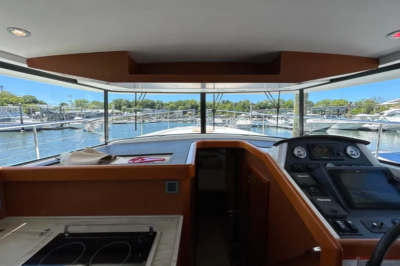 Slide: The Image of Interior view of 2018 Beneteau Swift Trawler 44, showcasing helm and marina scenery. - 12