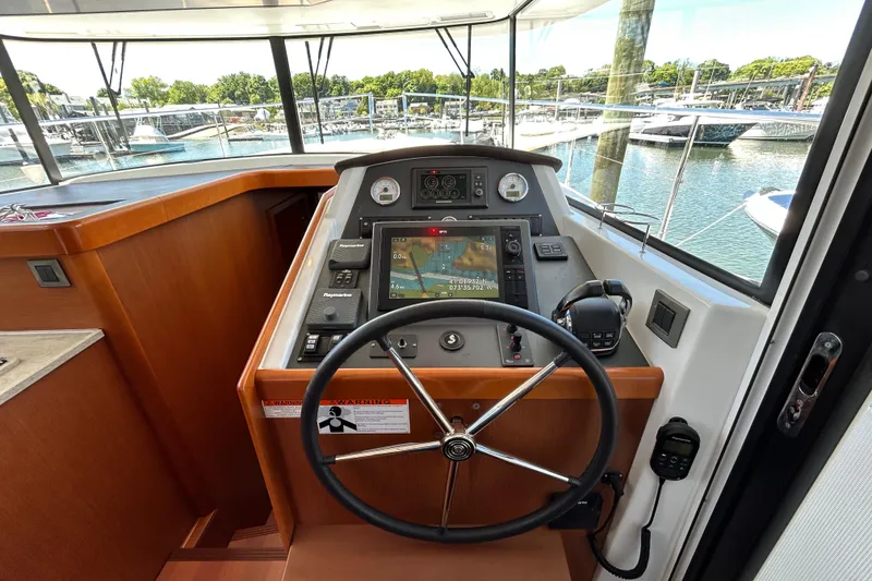 Slide: The Image of Helm of 2018 Beneteau Swift Trawler 44 with navigation equipment and steering wheel. - 14