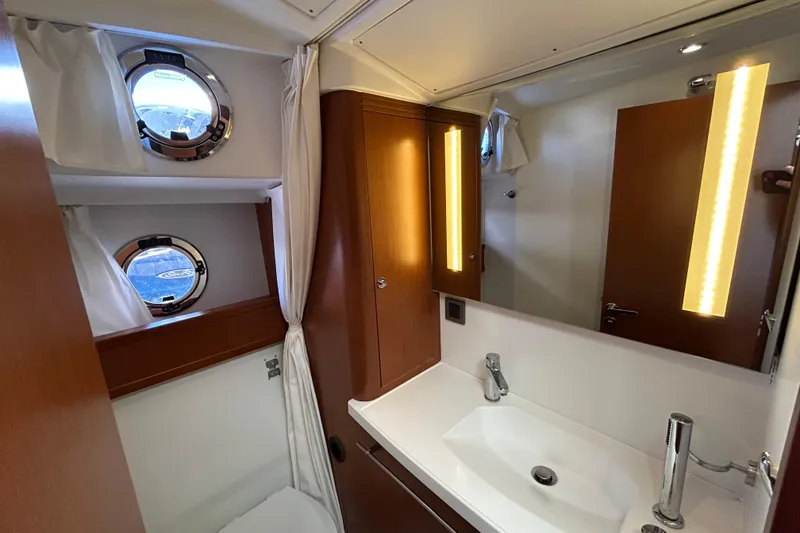 Slide: The Image of Luxurious bathroom in 2018 Beneteau Swift Trawler 44 with modern fixtures and porthole windows. - 17