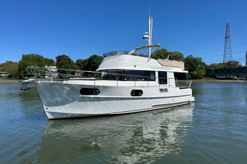 Slide: The Image of 2018 Beneteau Swift Trawler 44 on calm water, showcasing sleek design and modern features. - 2