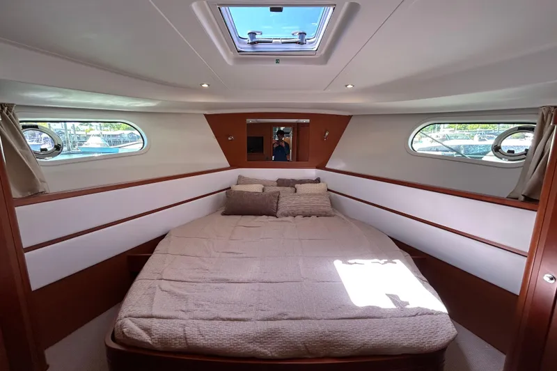 Slide: The Image of 2018 Beneteau Swift Trawler 44 cabin interior with cozy bed and porthole windows. - 20