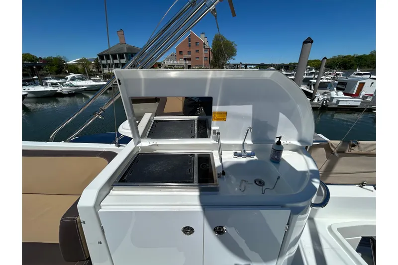 Slide: The Image of Outdoor kitchen on 2018 Beneteau Swift Trawler 44, featuring grill and sink at marina. - 23