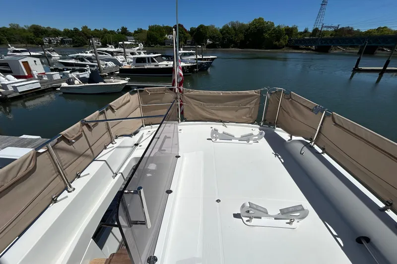 Slide: The Image of 2018 Beneteau Swift Trawler 44 docked, featuring spacious deck and marina view. - 24