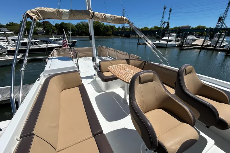 Slide: The Image of Flybridge of 2018 Beneteau Swift Trawler 44 with seating and table, docked at marina. - 25