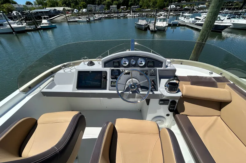 Slide: The Image of 2018 Beneteau Swift Trawler 44 helm with modern controls, docked in a marina. - 26