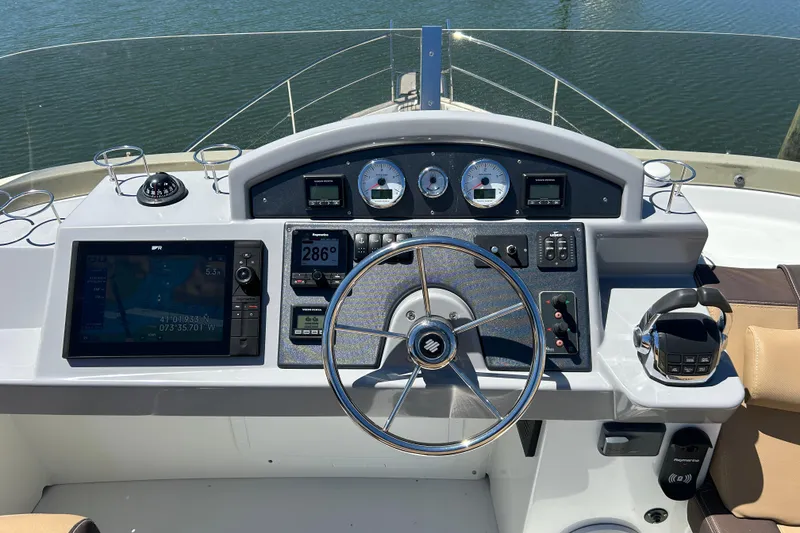 Slide: The Image of 2018 Beneteau Swift Trawler 44 helm with navigation instruments and steering wheel. - 27