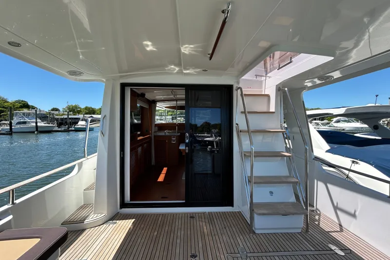 Slide: The Image of 2018 Beneteau Swift Trawler 44, featuring spacious deck and elegant interior, docked at marina. - 4