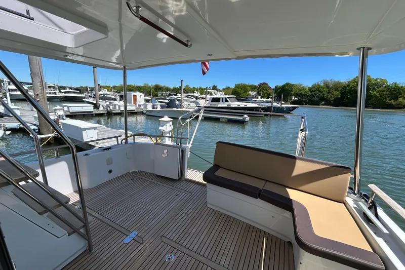 Slide: The Image of 2018 Beneteau Swift Trawler 44 at marina, featuring spacious deck and comfortable seating. - 5