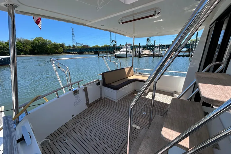 Slide: The Image of 2018 Beneteau Swift Trawler 44 deck with seating, overlooking marina and waterway. - 6
