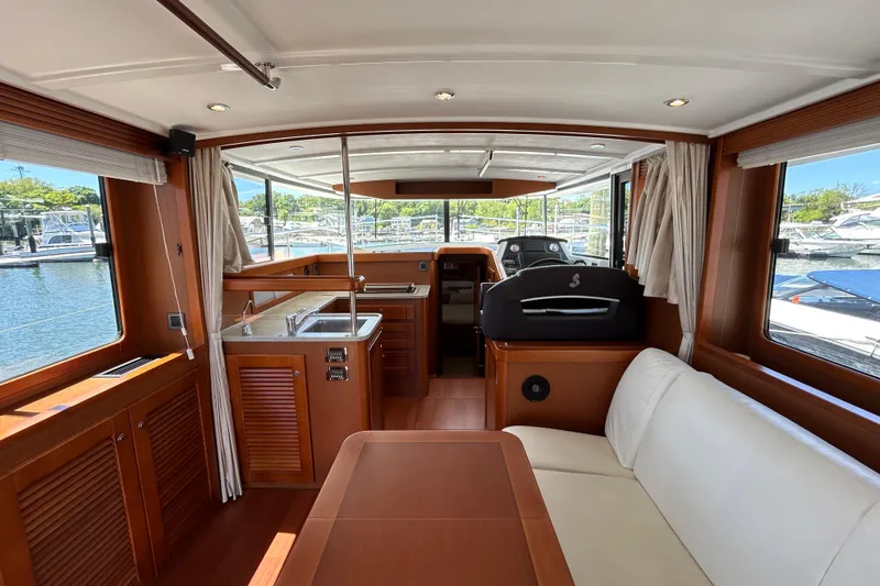 Slide: The Image of 2018 Beneteau Swift Trawler 44 interior with wood finish, kitchen, and seating area. - 8