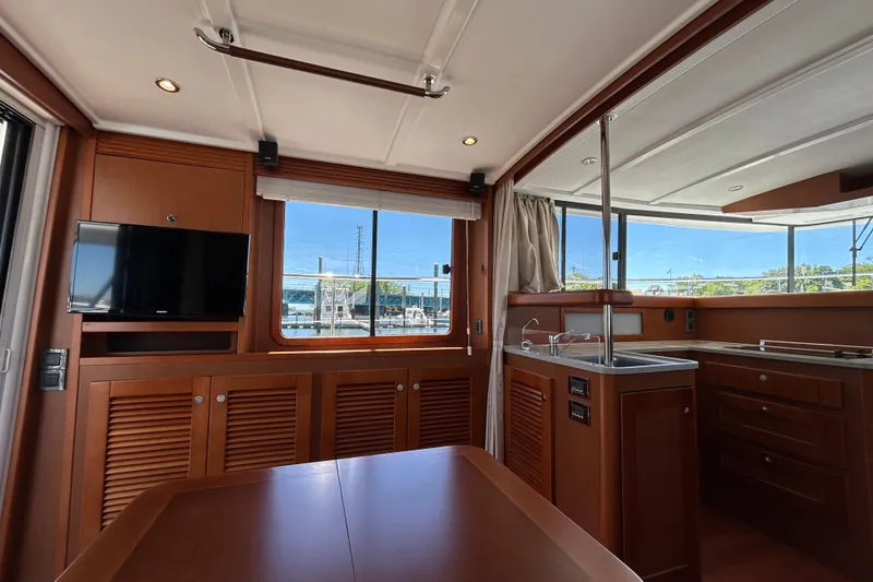 Slide: The Image of Interior of 2018 Beneteau Swift Trawler 44 with wood finish, TV, and kitchenette. - 9