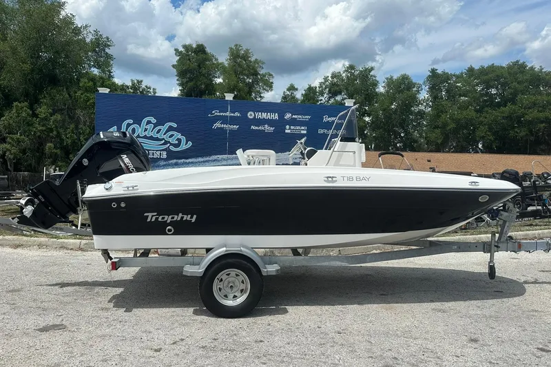 The Image of 2026 Bayliner Trophy T18 boat on trailer, displayed outdoors under cloudy sky. - 0