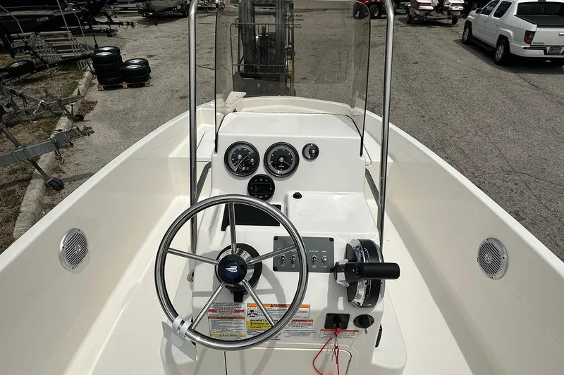 Slide: The Image of 2026 Bayliner Trophy T18 boat dashboard with steering wheel and gauges in a marina setting. - 16