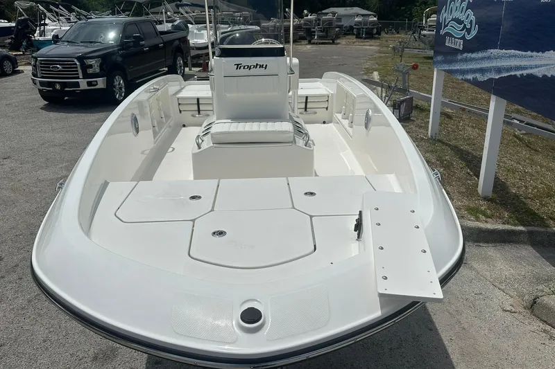 Slide: The Image of 2026 Bayliner Trophy T18 boat displayed in a marina parking lot. - 2