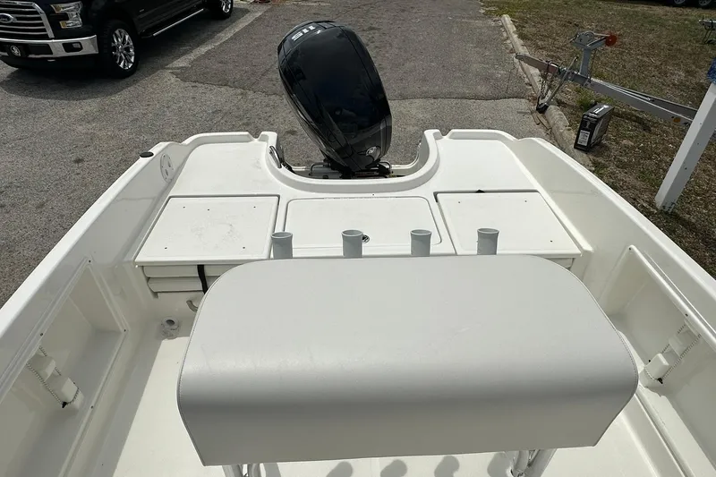 Slide: The Image of 2026 Bayliner Trophy T18 boat interior with motor and seating area. - 24