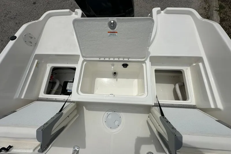 Slide: The Image of 2026 Bayliner Trophy T18 boat storage compartments and seating area. - 27