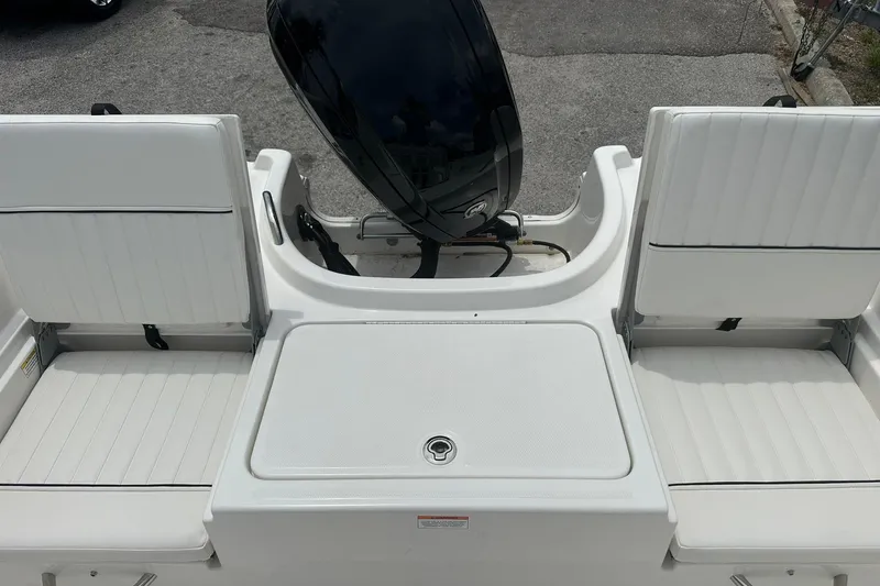 Slide: The Image of 2026 Bayliner Trophy T18 boat interior with white seating and motor view. - 28