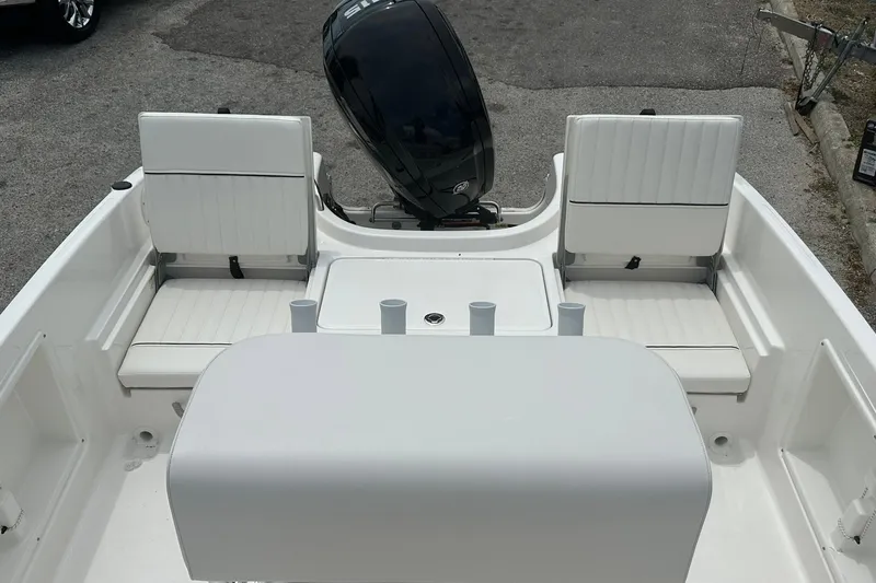 Slide: The Image of 2026 Bayliner Trophy T18 boat interior with white seating and motor view. - 31