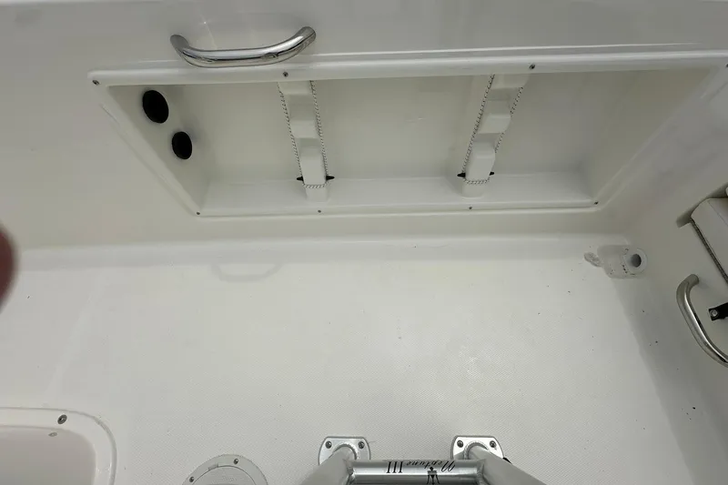 Slide: The Image of 2026 Bayliner Trophy T18 boat interior with storage compartment and stainless steel handle. - 32
