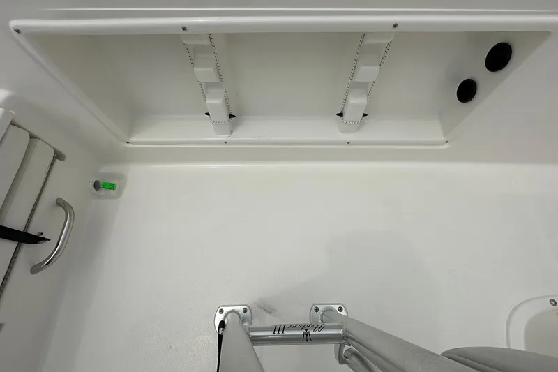 Slide: The Image of Interior view of 2026 Bayliner Trophy T18 boat, featuring storage compartment and stainless steel fittings. - 34