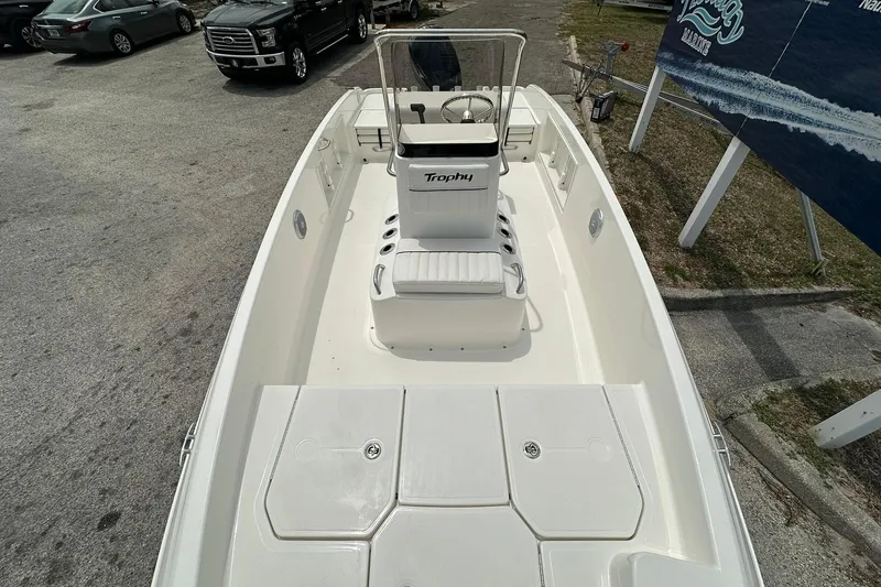 Slide: The Image of 2026 Bayliner Trophy T18 boat, white interior, parked outdoors, showcasing seating and steering console. - 6