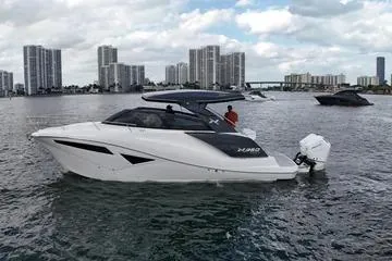 Slide: The Image of 2025 NX Boats NX360 Sport Coupe on water with city skyline backdrop. - 2
